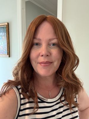 Woman_with_wavy_reddish-brown_hair_wearing_a_black_and_white_striped_s.jpg